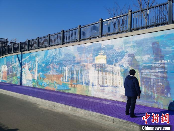 行人驻足欣赏墙上绘制的“新丝绸之路经济带”和“21世纪海上丝绸之路”沿线风景。　钟升 摄
