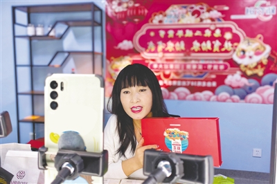 <p>　　丁成兰在手机前介绍产品。</p>