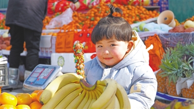 <p>　　跟随家人逛集市的小女孩得到了喜欢的冰糖葫芦。</p>