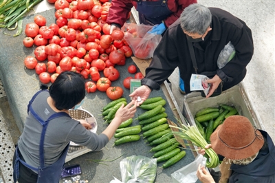 4月11日，顾客在山东烟台一家市场买菜。新华社发