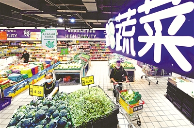 10月4日，新百连超银川兴庆府店，工作人员正在上架蔬菜。 本报记者 王晓龙 摄