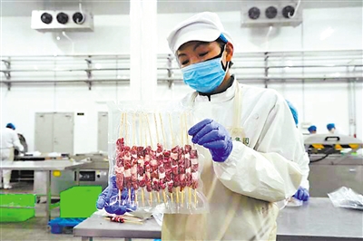 宁夏盐池滩羊产业发展集团有限公司下属公司生产车间内，工人在包装羊肉串。