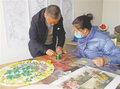 <p>　　冒万学和妻子制作羊皮画。</p>