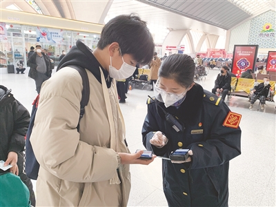 杨倩在检票口为旅客预检车票。银川火车站供图