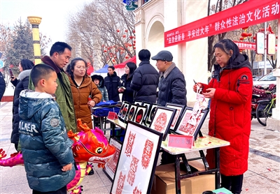 非遗剪纸传承人陈玉慧现场为群众剪“法治剪纸”。