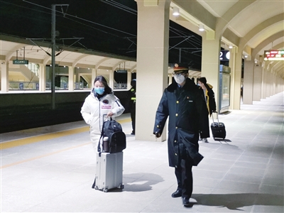     深夜的站台上，王永刚引导旅客上下车。