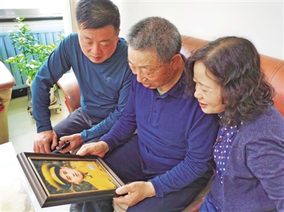 <p>　　郭英汉（中）和子女瞻仰郭占鳌的照片。</p>