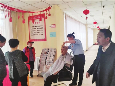     李静给社区老人理发。
