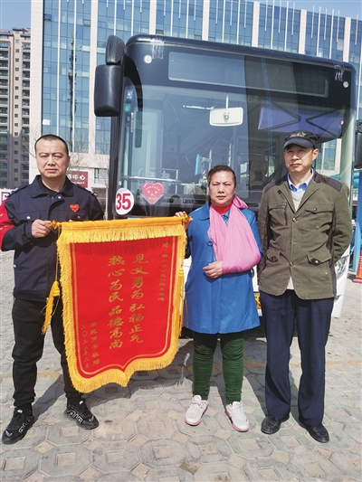 罗女士和丈夫送锦旗致谢。 本报记者  邱曦   摄