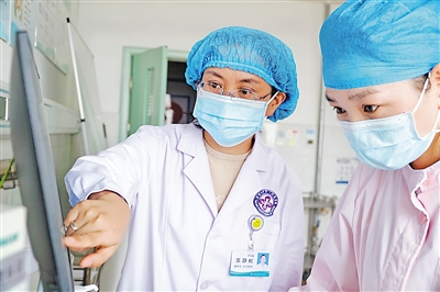     石嘴山市第一人民医院副院长张静虹（左）与医护人员查看患者数据。