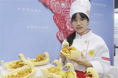 <p>　　袁晓平在大赛现场展示自己的花艺面点作品。</p>