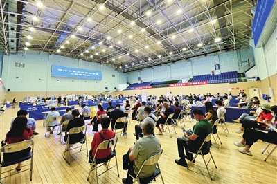 8月10日，在宁夏亲水体育中心比赛馆，市民排队等待接种疫苗。据悉，该方舱接种点8月11日至17日为辖区15—17岁人群集中接种，18日恢复为成年人接种。　本报记者  季正  摄