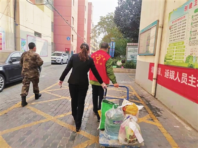 陈勇（右）和社区工作者正在给被封控居民送货。